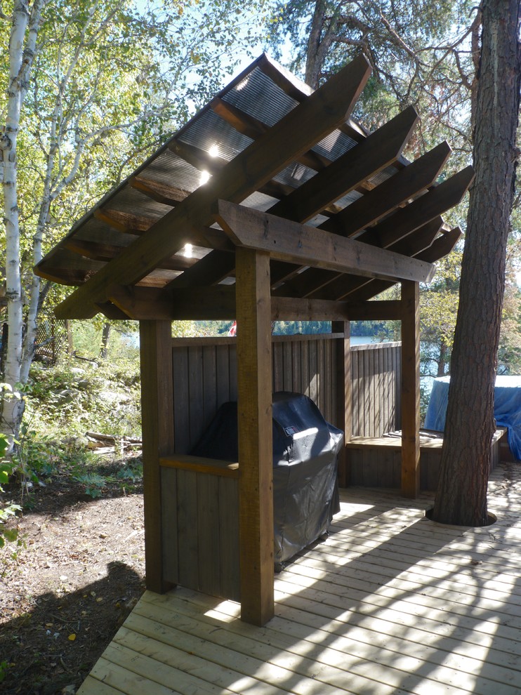 Outdoor kitchen deck - mid-sized side yard outdoor kitchen deck idea with a pergola