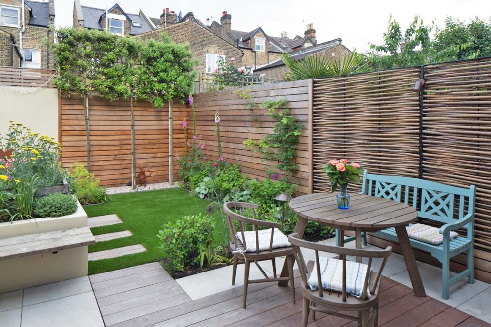This is an example of a country backyard garden in London with a garden path and concrete pavers.