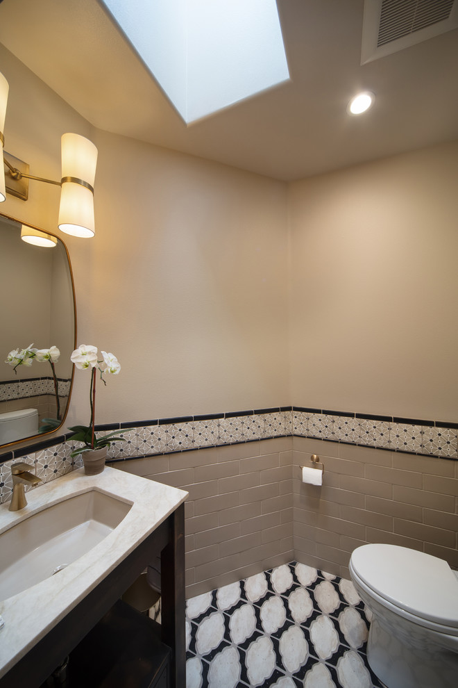 This is an example of a small transitional bathroom in San Luis Obispo with open cabinets, black cabinets, a two-piece toilet, beige tile, multi-coloured tile, subway tile, beige walls, ceramic floors, an undermount sink, marble benchtops, multi-coloured floor and grey benchtops.
