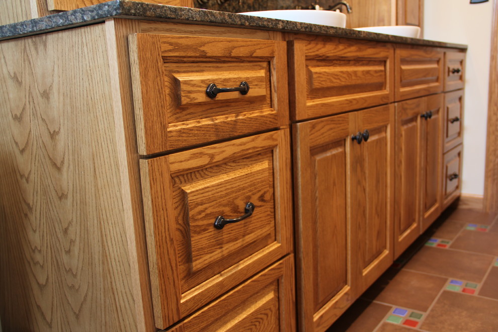 Example of a transitional brown tile and porcelain tile porcelain tile tub/shower combo design in Columbus with a vessel sink, an undermount tub, a two-piece toilet, raised-panel cabinets, medium tone wood cabinets, granite countertops and beige walls