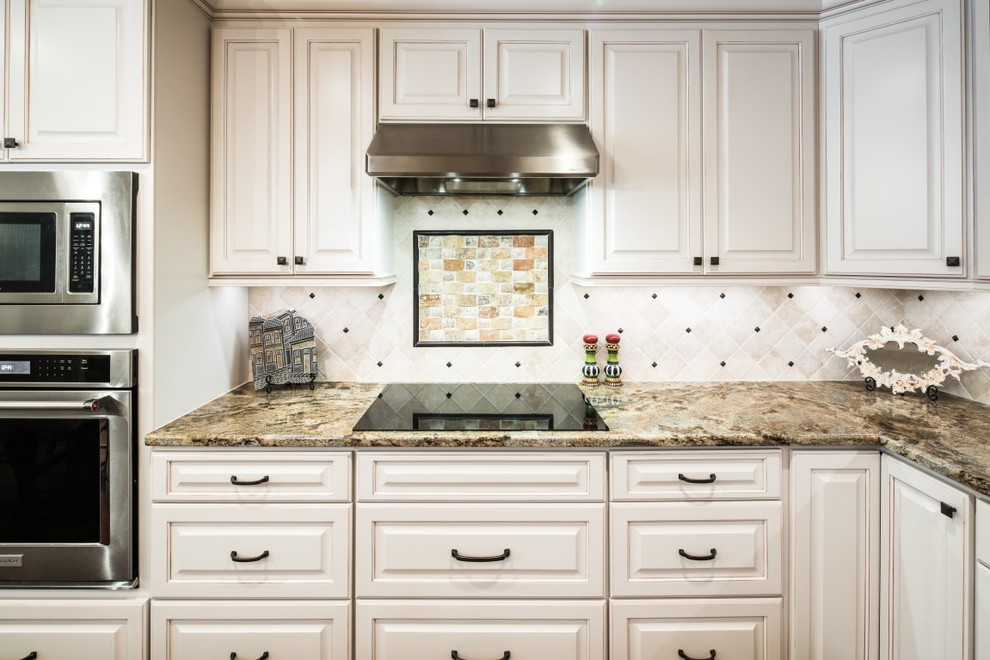Inspiration for a large traditional l-shaped kitchen in Austin with raised-panel cabinets, white cabinets, granite benchtops, grey splashback, ceramic splashback and stainless steel appliances.