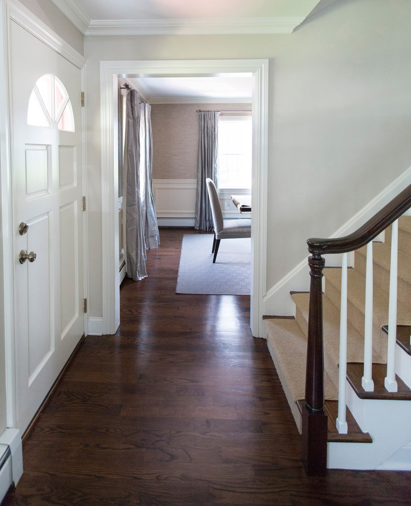 Mid-sized transitional entry hall in New York with grey walls, dark hardwood floors, a single front door, a white front door and brown floor.