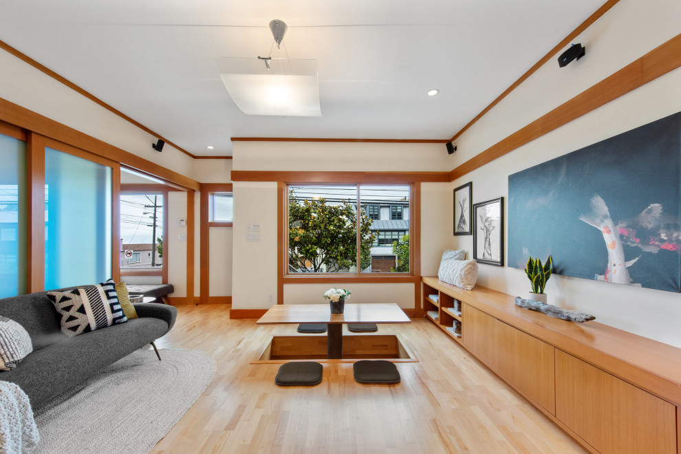 Photo of a small asian open concept living room in San Francisco with white walls, light hardwood floors, beige floor and wood walls.