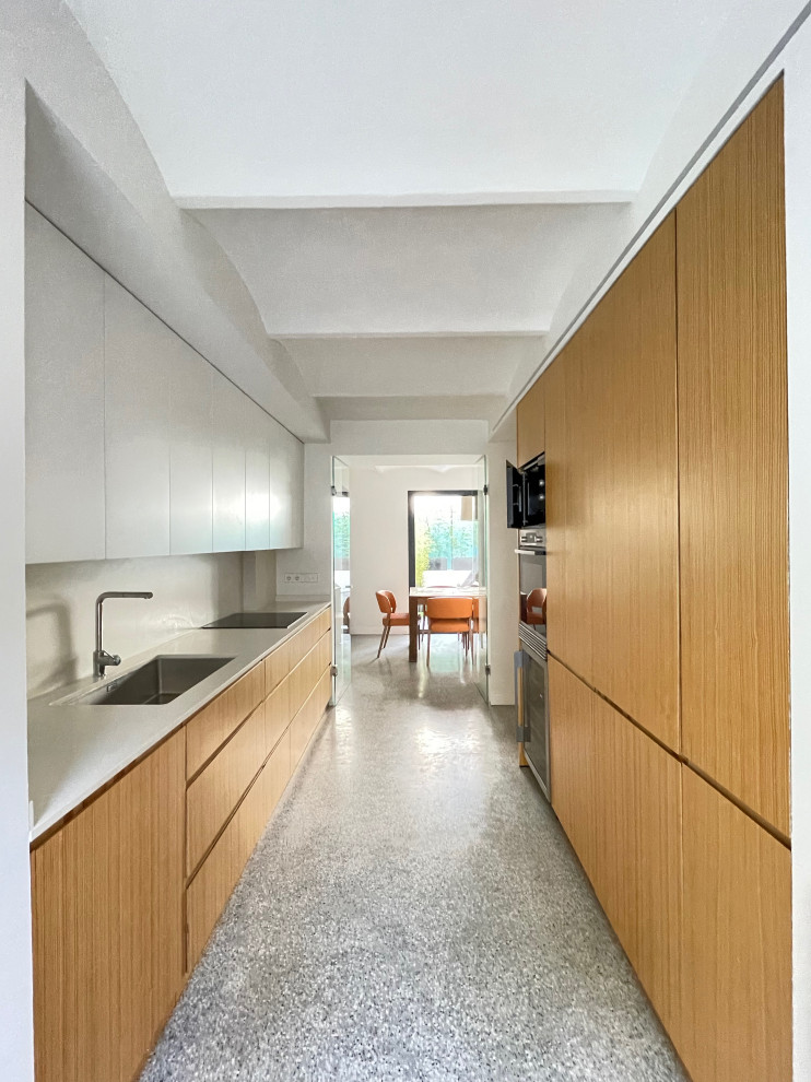 Exempel på ett avskilt, mellanstort modernt vit vitt kök, med en undermonterad diskho, släta luckor, skåp i ljust trä, marmorbänkskiva, vitt stänkskydd, stänkskydd i marmor, integrerade vitvaror, terrazzogolv och grått golv