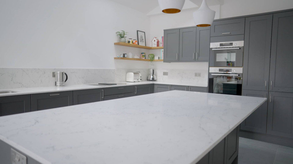 Design ideas for a medium sized traditional l-shaped open plan kitchen in Sussex with shaker cabinets, quartz worktops, an island and white worktops.