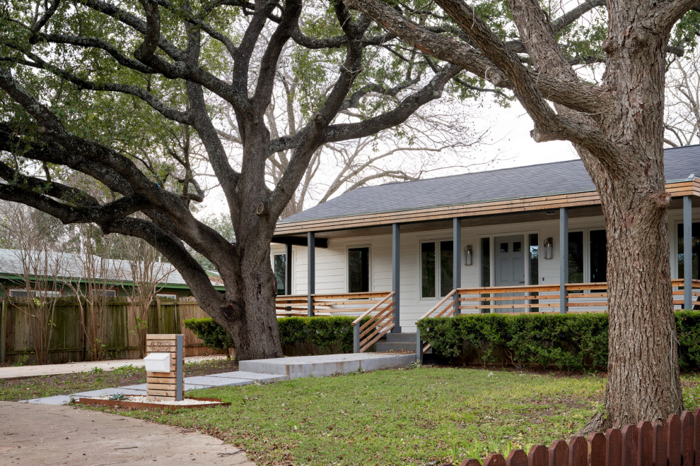 This is an example of a medium sized midcentury bungalow house exterior in Austin with a half-hip roof.