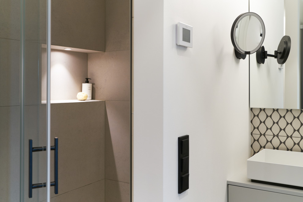 Blick in die Duschnische mit Glastür neben dem grauen Waschtisch