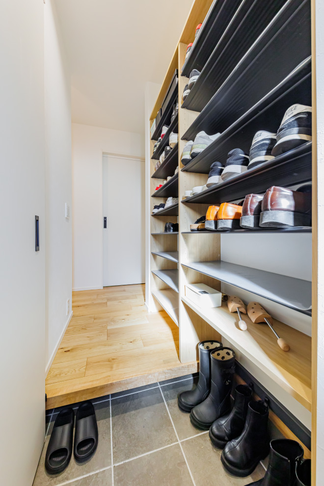 Example of a mid-sized minimalist wallpaper ceiling and wallpaper entryway design in Kobe with white walls and a black front door