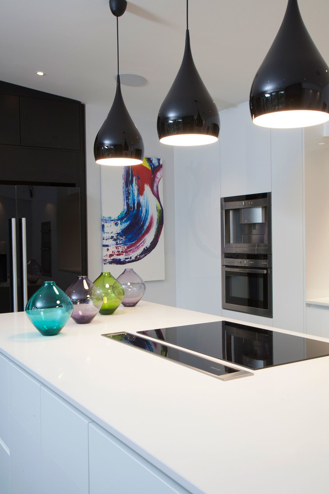 This is an example of a mid-sized contemporary l-shaped kitchen pantry in London with a single-bowl sink, flat-panel cabinets, white cabinets, black splashback, ceramic splashback, stainless steel appliances, ceramic floors and a peninsula.