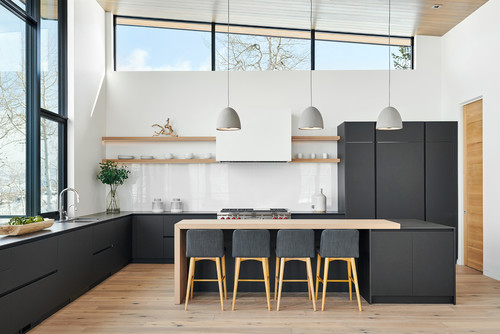 Minimalist kitchen with handleless RTA cabinets in matte black, light wood island, and open shelves for visual continuity