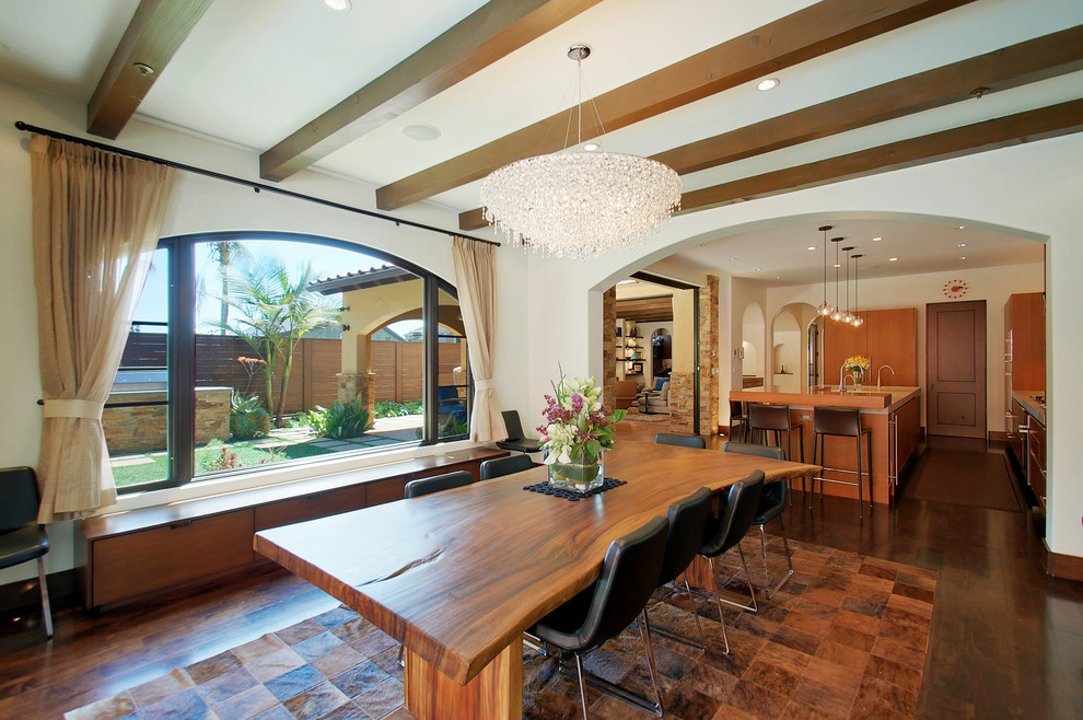 This is an example of a mediterranean dining room in Los Angeles with white walls and dark hardwood floors.