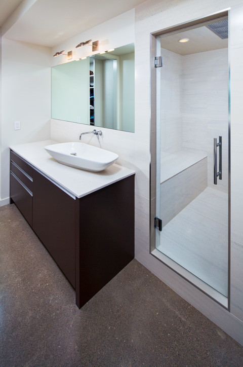 Design ideas for a mid-sized modern master bathroom in Calgary with flat-panel cabinets, dark wood cabinets, an alcove shower, white walls, terrazzo floors, a vessel sink and solid surface benchtops.