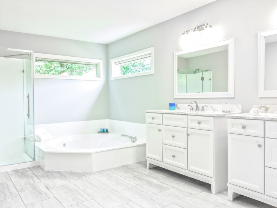 Photo of a mid-sized transitional master bathroom in Columbus with flat-panel cabinets, white cabinets, a corner tub, a corner shower, a two-piece toilet, beige tile, grey walls, ceramic floors, granite benchtops, grey floor, a hinged shower door, white benchtops, an enclosed toilet, a double vanity and a freestanding vanity.