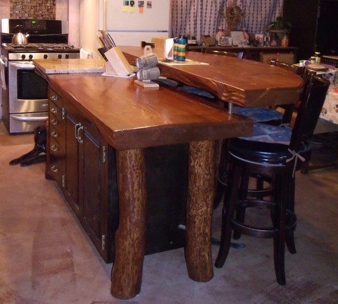 Kitchen - mid-sized rustic kitchen idea in Albuquerque with raised-panel cabinets, dark wood cabinets, wood countertops, stainless steel appliances and an island