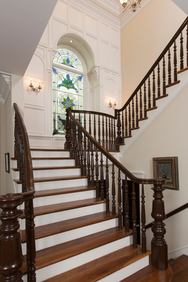 Huge elegant wooden u-shaped wood railing staircase photo in Houston with wooden risers