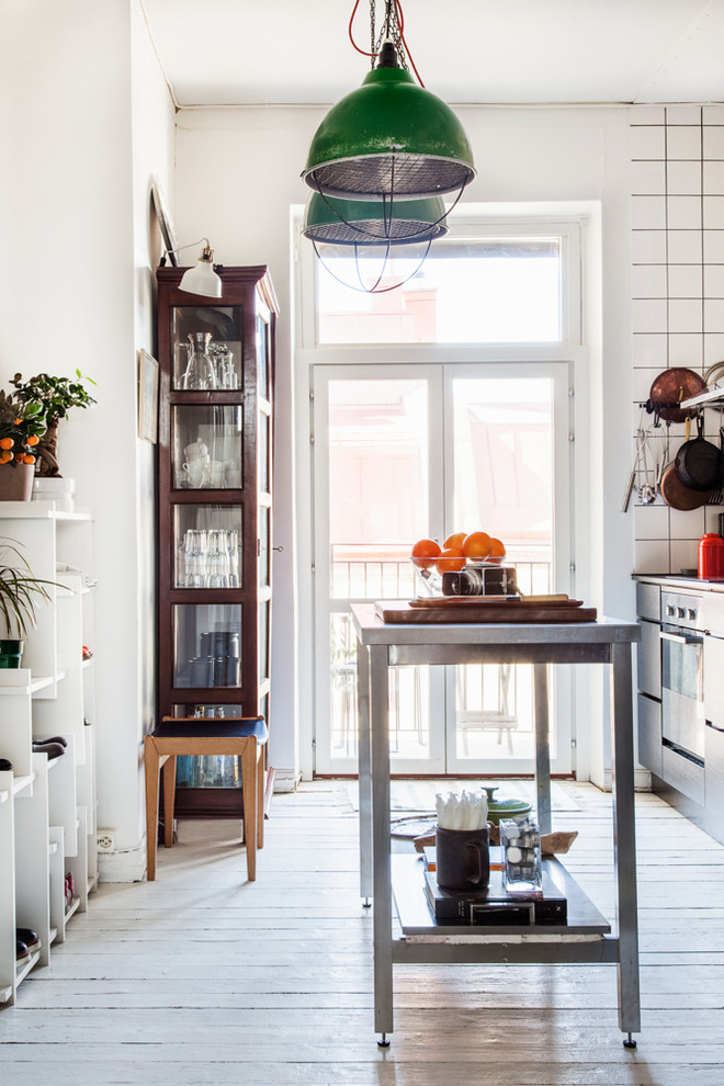 This is an example of a mid-sized eclectic kitchen in Gothenburg with light hardwood floors, with island and beige floor.