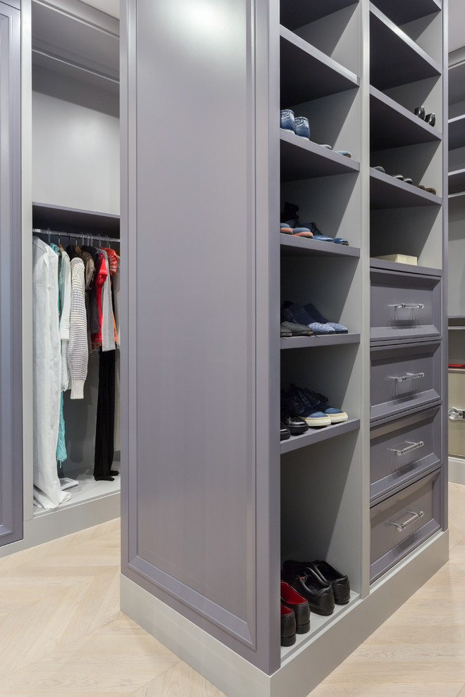 Mid-sized scandinavian gender-neutral walk-in wardrobe in Moscow with raised-panel cabinets, grey cabinets, medium hardwood floors and grey floor.