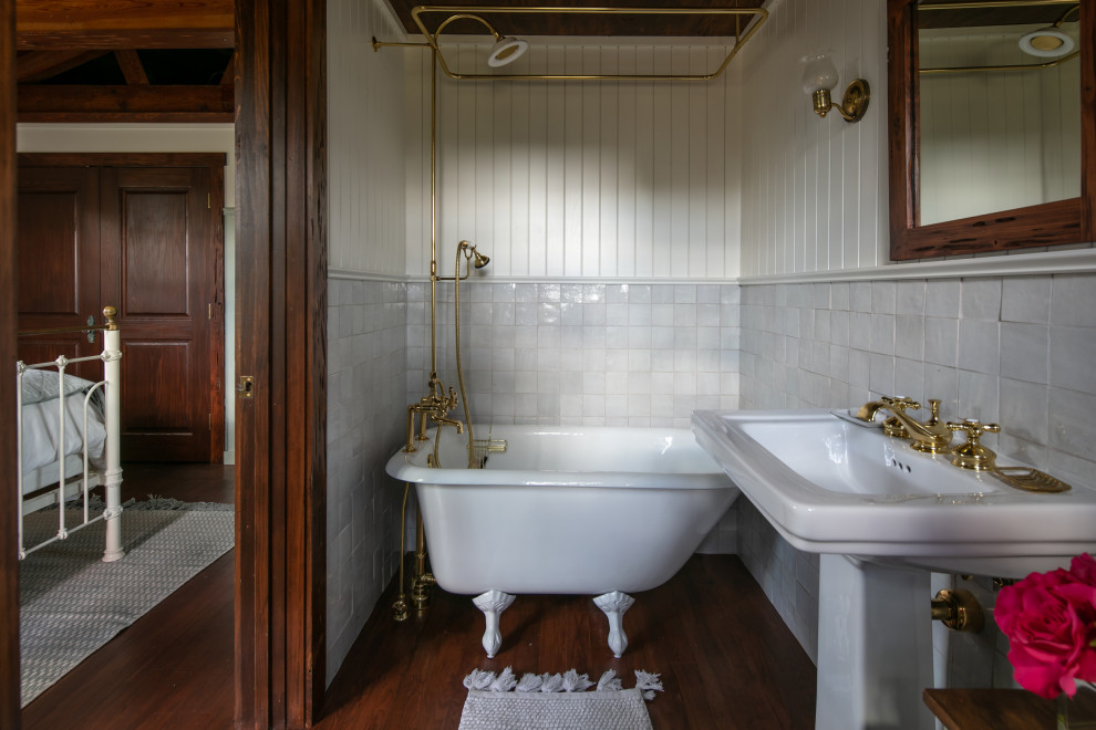 Inspiration for a mid-sized country master bathroom in Tampa with a claw-foot tub, a shower/bathtub combo, white tile, ceramic tile, dark hardwood floors, a pedestal sink, a shower curtain, a single vanity, wood and planked wall panelling.