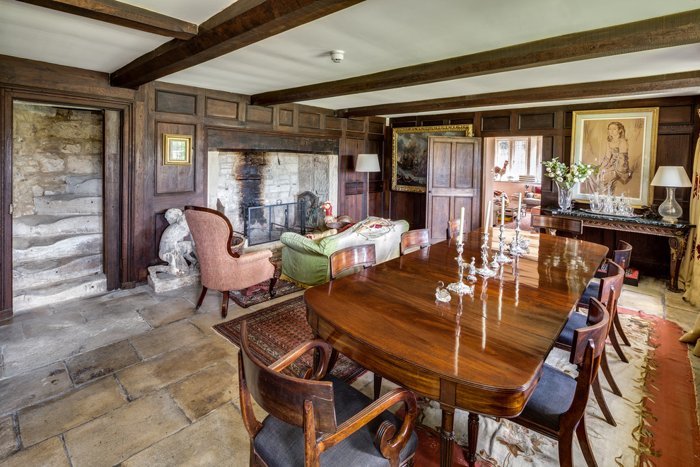 Inspiration for a mid-sized traditional dining room in Gloucestershire with brown walls, a standard fireplace and grey floor.