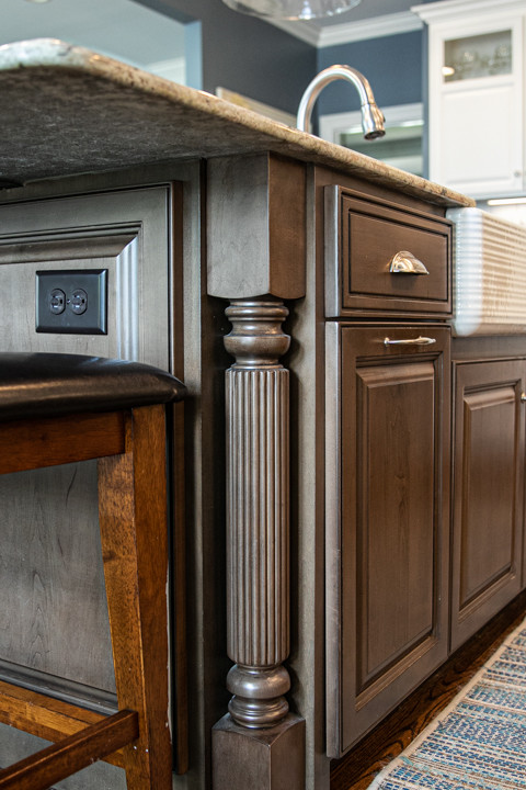 Large transitional l-shaped medium tone wood floor and brown floor open concept kitchen photo in Charlotte with a farmhouse sink, white cabinets, granite countertops, white backsplash, stainless steel appliances, an island, raised-panel cabinets, porcelain backsplash and white countertops