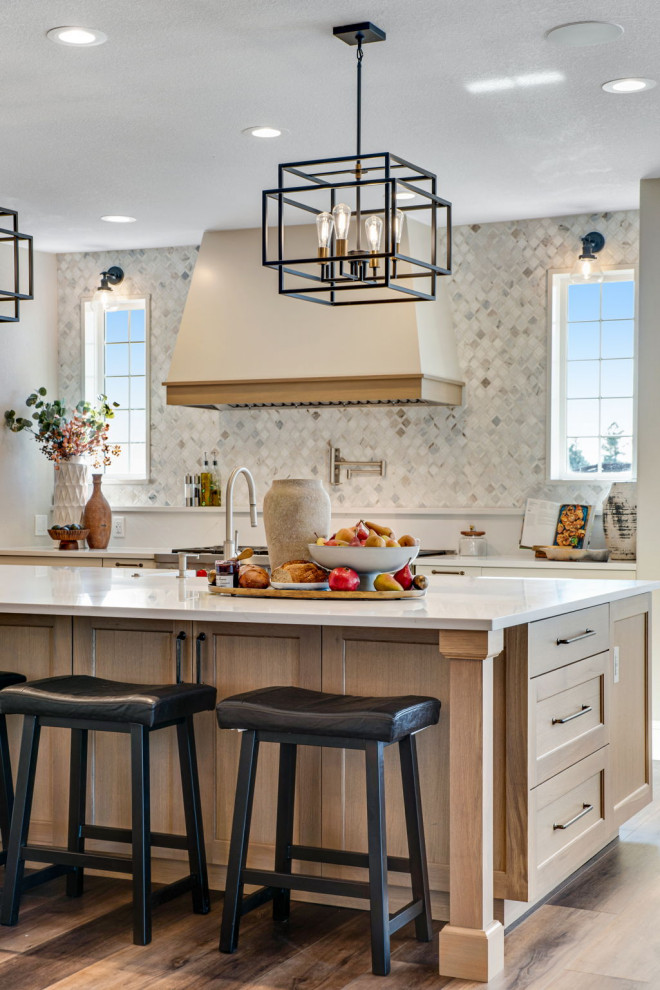 Inspiration for a large country u-shaped open plan kitchen in Denver with a farmhouse sink, recessed-panel cabinets, white cabinets, quartz benchtops, white splashback, mosaic tile splashback, stainless steel appliances, vinyl floors, with island, brown floor and white benchtop.