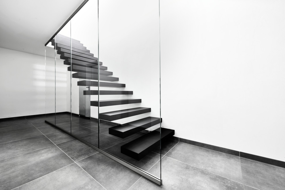 Консольная лестница в черном матовом цвете с ограждением из белого стекла