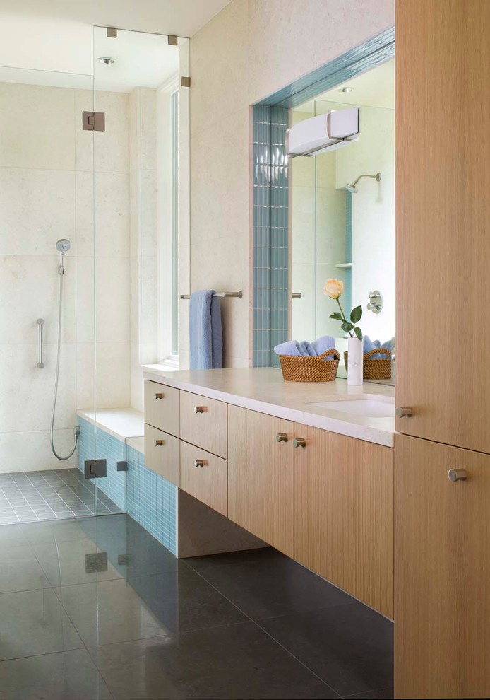 Photo of a contemporary bathroom in Denver with an undermount sink, flat-panel cabinets, medium wood cabinets, a curbless shower, beige tile and beige walls.