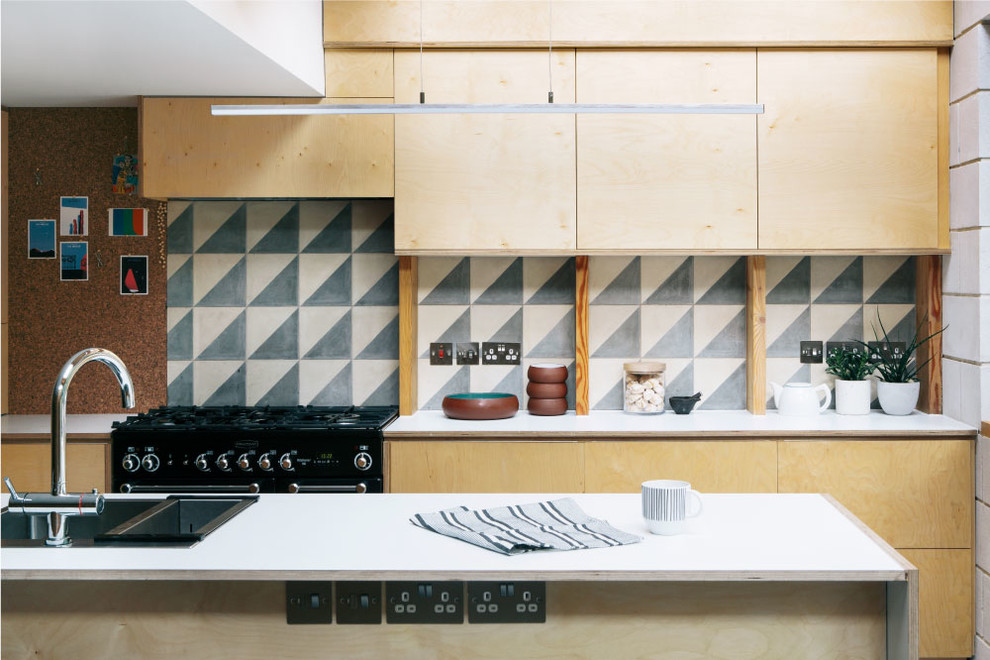 Photo of a small scandinavian single-wall kitchen in London with a double-bowl sink, flat-panel cabinets, light wood cabinets, cement tile splashback and with island.