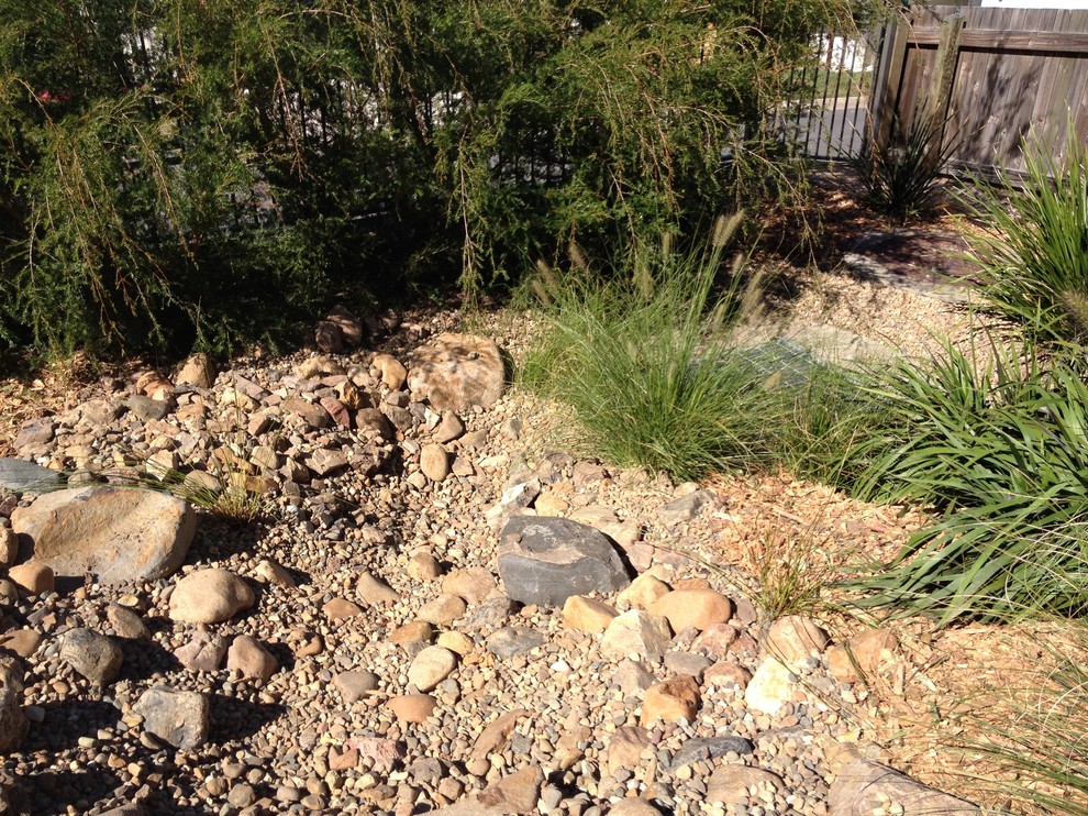 Inspiration for a mid-sized country sloped garden in Sunshine Coast with a water feature.
