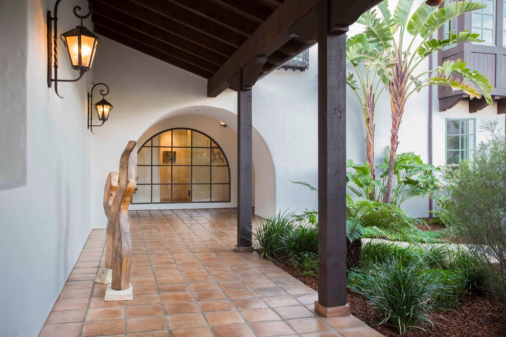 Inspiration for a large mediterranean two-storey adobe white exterior in Santa Barbara with a hip roof.