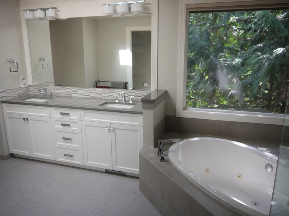 Large transitional master bathroom in Seattle with shaker cabinets, white cabinets, a drop-in tub, gray tile, porcelain tile, grey walls, linoleum floors, an undermount sink, engineered quartz benchtops, grey floor, a hinged shower door and grey benchtops.