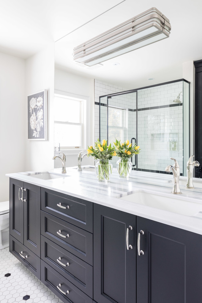 This is an example of an expansive contemporary master bathroom in Toronto with beaded inset cabinets, black cabinets, a double shower, a one-piece toilet, black and white tile, ceramic tile, white walls, ceramic floors, an undermount sink, marble benchtops, white floor, a hinged shower door and white benchtops.