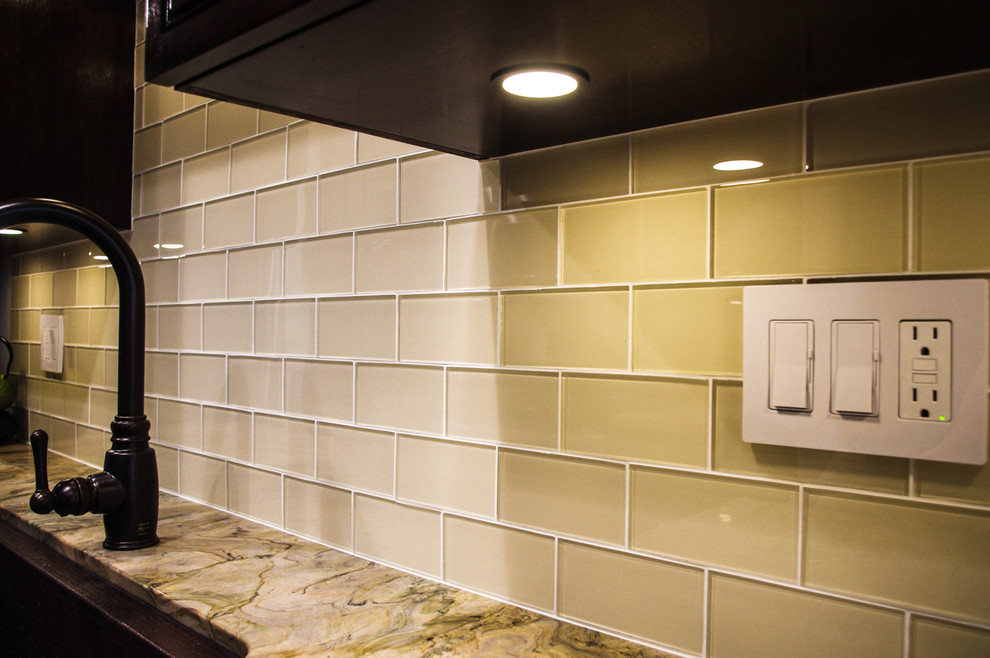 Inspiration for a transitional medium tone wood floor kitchen remodel with raised-panel cabinets, white cabinets, granite countertops, beige backsplash, glass tile backsplash and stainless steel appliances