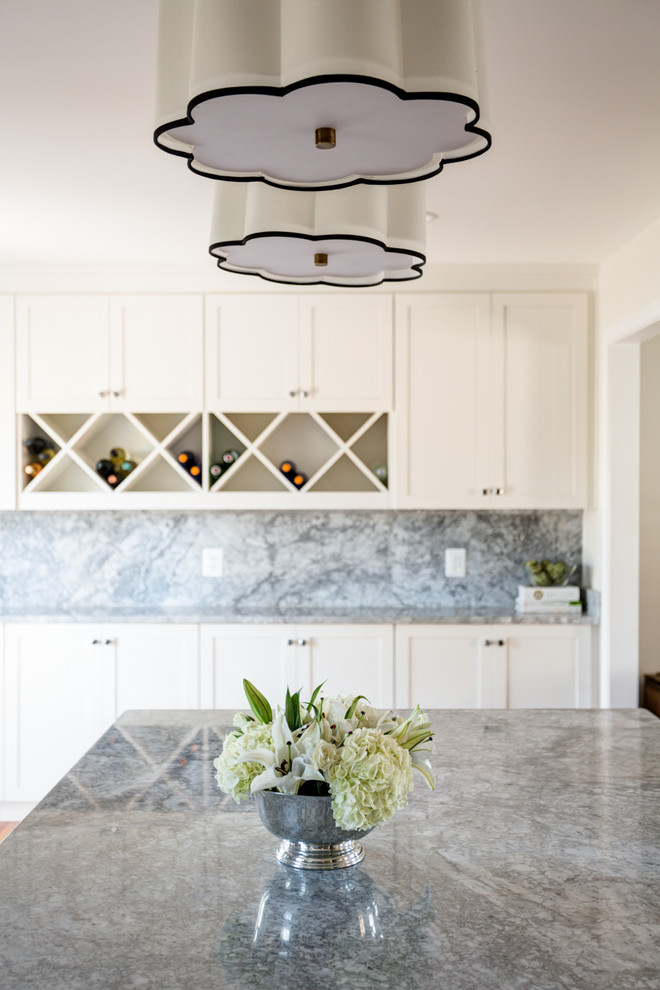 Example of a transitional light wood floor kitchen pantry design with a single-bowl sink, shaker cabinets, white cabinets, quartzite countertops, gray backsplash, stone slab backsplash, stainless steel appliances and an island