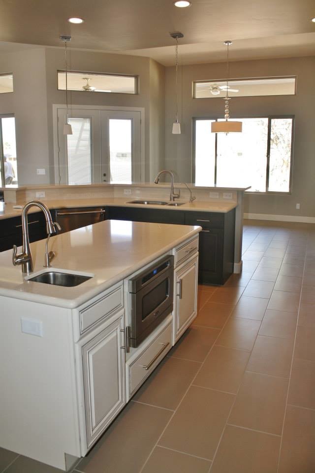 Eat-in kitchen - large transitional u-shaped porcelain tile eat-in kitchen idea in Phoenix with raised-panel cabinets, dark wood cabinets, quartz countertops, an island, an undermount sink, beige backsplash, stone tile backsplash and stainless steel appliances