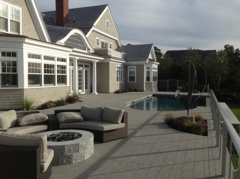 Photo of a large beach style backyard patio in Boston with a fire feature and concrete slab.