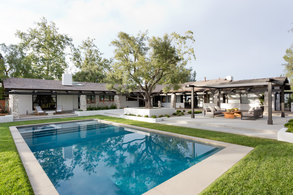 Design ideas for a midcentury backyard rectangular lap pool in Los Angeles with a hot tub and concrete slab.