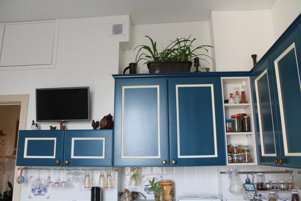 Mid-sized traditional l-shaped separate kitchen in Moscow with an undermount sink, beaded inset cabinets, blue cabinets, solid surface benchtops, white splashback, ceramic splashback, panelled appliances, no island and white benchtop.