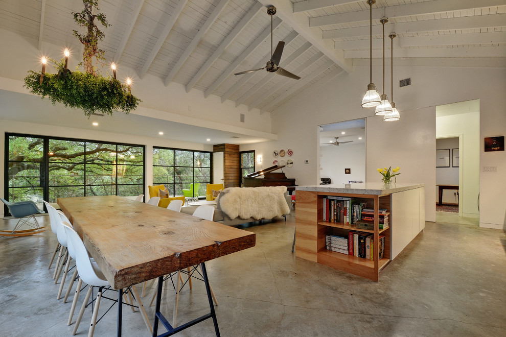Large eclectic open plan dining in Austin with white walls, concrete floors and no fireplace.