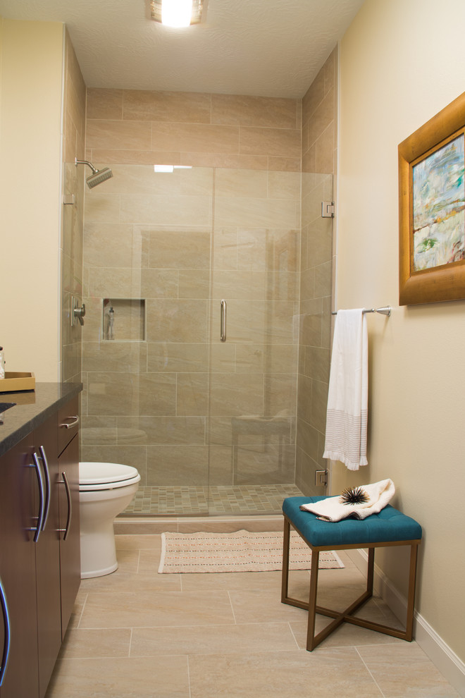 Alcove shower - mid-sized transitional 3/4 beige tile and ceramic tile ceramic tile alcove shower idea with flat-panel cabinets, dark wood cabinets, a two-piece toilet, beige walls, an undermount sink and granite countertops