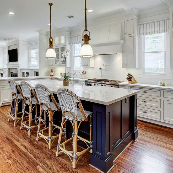 Inspiration for a large transitional u-shaped open plan kitchen in Denver with a farmhouse sink, shaker cabinets, white cabinets, limestone benchtops, white splashback, porcelain splashback, stainless steel appliances, medium hardwood floors, with island, brown floor and grey benchtop.