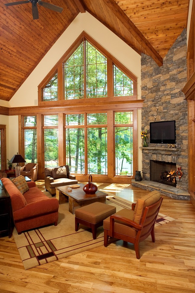 Country living room in Other with a corner fireplace and a wall-mounted tv.