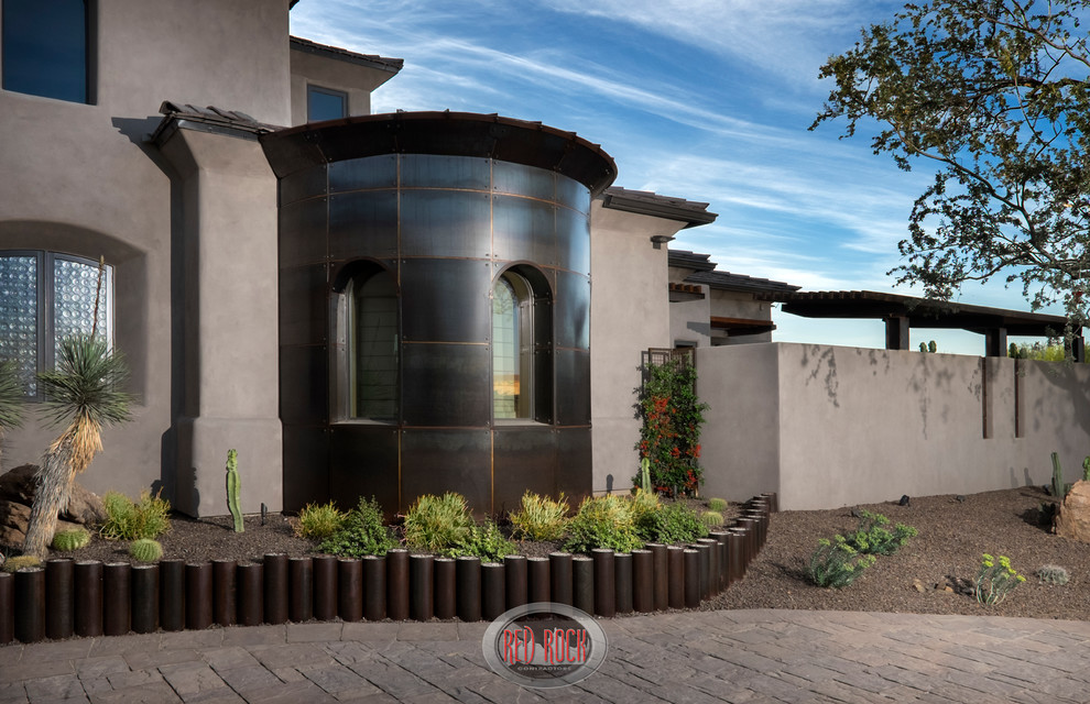 This is an example of a large industrial front yard partial sun xeriscape in Phoenix with brick pavers.