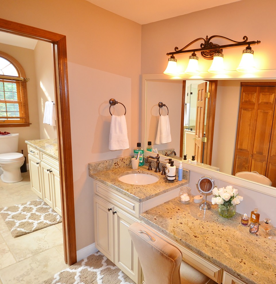 Large traditional master bathroom in Philadelphia with recessed-panel cabinets, white cabinets, a freestanding tub, a corner shower, a one-piece toilet, beige tile, ceramic tile, beige walls, ceramic floors, an undermount sink and granite benchtops.