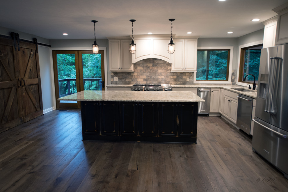 Eat-in kitchen - large transitional l-shaped medium tone wood floor and brown floor eat-in kitchen idea in Indianapolis with an undermount sink, raised-panel cabinets, white cabinets, granite countertops, multicolored backsplash, porcelain backsplash, stainless steel appliances and an island