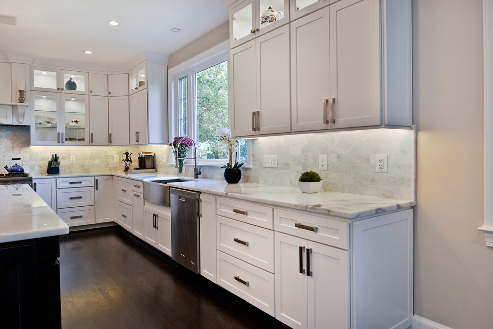 Design ideas for a large modern eat-in kitchen in DC Metro with a farmhouse sink, white cabinets, quartzite benchtops, white splashback, travertine splashback, stainless steel appliances, dark hardwood floors, with island, brown floor and white benchtop.