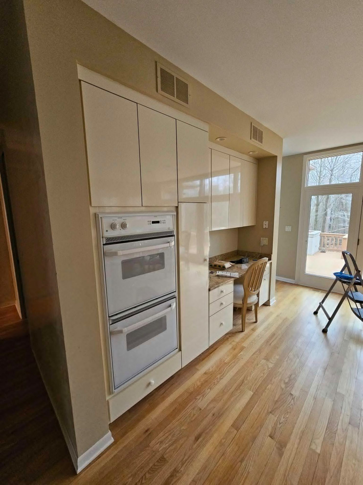 Inspiration for a large transitional medium tone wood floor and brown floor eat-in kitchen remodel in Chicago with an undermount sink, shaker cabinets, medium tone wood cabinets, quartz countertops, multicolored backsplash, stone tile backsplash, stainless steel appliances, an island and white countertops