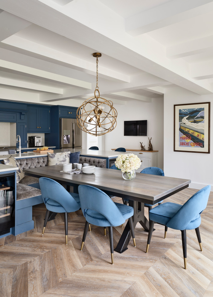 Inspiration for a large modern eat-in kitchen in Buckinghamshire with an integrated sink, shaker cabinets, blue cabinets, quartzite benchtops, white splashback, glass sheet splashback, black appliances, light hardwood floors, with island, beige floor, white benchtop and exposed beam.