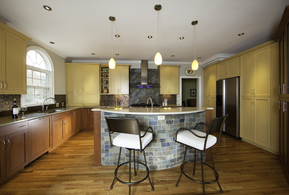 Eclectic l-shaped kitchen photo in Charlotte with recessed-panel cabinets, yellow cabinets, multicolored backsplash and stainless steel appliances