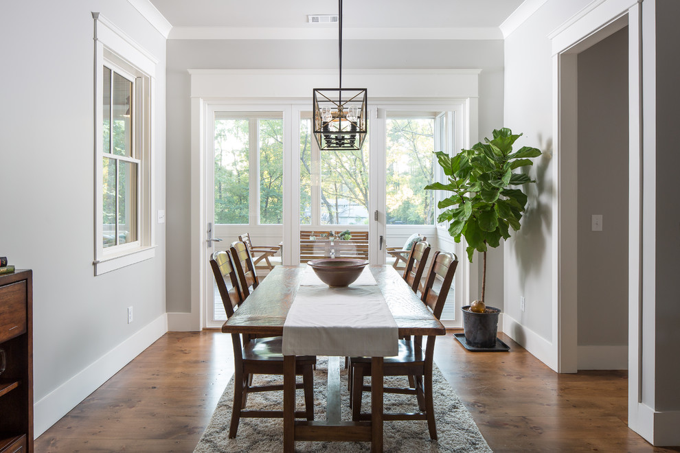 This is an example of a country separate dining room in Atlanta with grey walls, medium hardwood floors and brown floor.